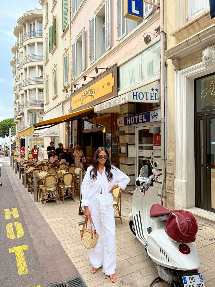 a woman in white outfit standing in front of a restaurant